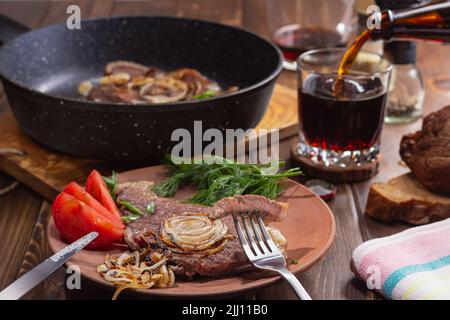 morceau de bœuf marbré grillé broché sur la fourchette accent sur la viande. poêle avec steak de bœuf entier flou.concept de nourriture saine. passe-temps chaleureux et copieux en soirée Banque D'Images