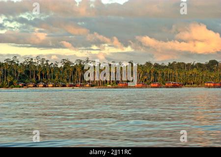 Vue sur une plage décorée de chalets en bois et de cocotiers sur l'île de Maratua, dans la zone marine protégée de Berau, dans les îles Derawan, Berau, Kalimantan est, Indonésie. Banque D'Images