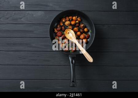 Poêle de champignons frits sur fond de bois sombre. Vue de dessus. Place pour le texte et l'espace de copie. Les champignons sont enrichis d'un grand nombre de Banque D'Images