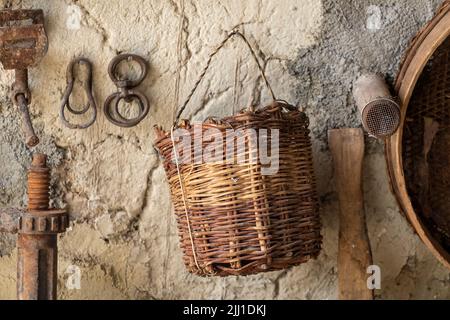 Photo sélective de biens du vieux village et panier en bois tricoté accroché au mur. Banque D'Images