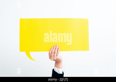Femme d'affaires tenant la bulle de discours avec des messages importants d'une main. Femme présentant des informations de base sur le ballon de dialogue. Lady montrant Banque D'Images