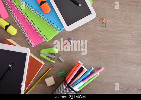 Fournitures scolaires et dispositifs électroniques pour l'enseignement et l'apprentissage sur un bureau en bois. Vue de dessus Banque D'Images