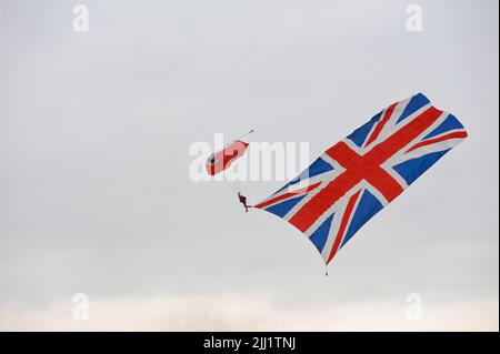 Un membre de l'équipe de parachutisme des Red Falcons débarquant à l'occasion d'un saut à l'exposition au Farnborough International Airshow (FIA) qui se déroule à Farnborough, Hampshire, au Royaume-Uni. Le spectacle aérien, une vitrine semestrielle pour l'industrie de l'aviation, est le plus grand de son genre et attire des acheteurs civils et militaires du monde entier. Les visiteurs commerciaux sont normalement de plus de 100 000 personnes. Le côté commercial du spectacle est suivi d'un week-end d'expositions aériennes destinées au grand public. Une énorme quantité d'affaires est faite au salon et le dernier salon en 2018 a vu 192 milliards de dollars US d'affaires d Banque D'Images