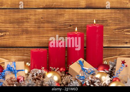 Les bougies rouges de Noël avec des cônes et des jouets Banque D'Images