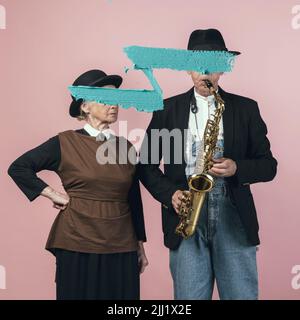 Homme et femme âgés en costume rétro avec des traits bleus sur leur visage. Style rétro, comparaison des époques et concept culturel. Banque D'Images