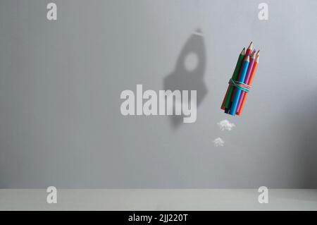 Crayon dans l'air avec l'ombre d'une fusée, de retour à l'école, le succès; réaliser des rêves concept Banque D'Images