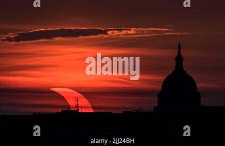 Une éclipse solaire partielle est vue comme le soleil se lève à gauche du bâtiment du Capitole des États-Unis, le jeudi 10 juin 2021, comme vu d'Arlington, Virginie. L'éclipse solaire annulaire ou « anneau de feu » n'est visible que par certaines personnes au Groenland, dans le nord de la Russie et au Canada. Crédit photo : (NASA/Bill Ingalls) Banque D'Images