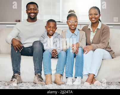 Toujours garder la famille à proximité. Une jeune famille se détend ensemble à la maison. Banque D'Images