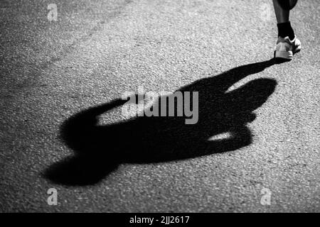 ombre du coureur sur asphalte foncé la nuit Banque D'Images