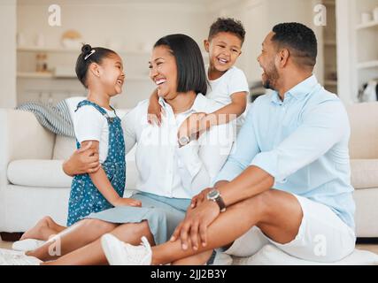 La famille est comme cette agaçante petite chose qu'on ne peut pas rayer. Une jeune famille se bondit volontiers à l'étage à la maison. Banque D'Images