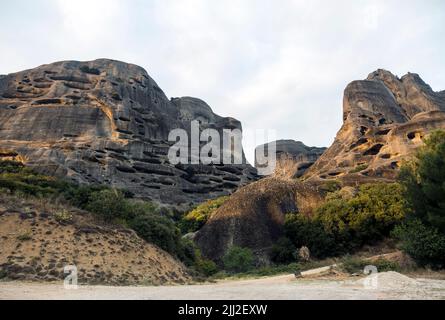 Mystérieuses grottes naturelles pour moines dans les formations rocheuses de Meteora, Grèce. Belles couches de montagnes brumeuses Banque D'Images