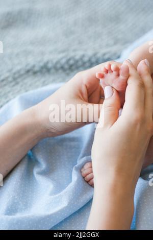 la mère fait un massage des pieds à un nouveau-né Banque D'Images