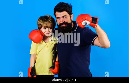 Petit garçon en gants de boxe avec entraîneur. Entraîneur et boxeur pour enfants se tiennent ensemble. Style de vie sportif. Banque D'Images