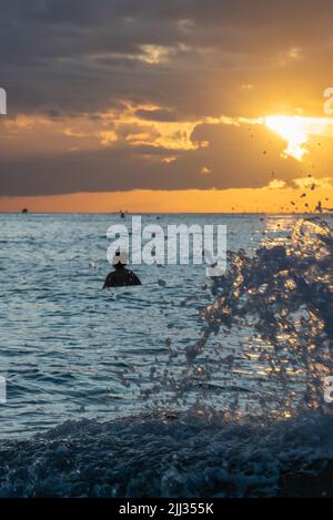 Vue portrait d'un magnifique coucher de soleil hawaïen sur le rivage sablonneux en papier peint, vue sur le bureau. Banque D'Images