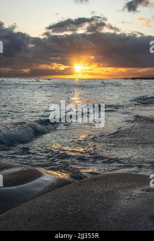 Vue portrait d'un magnifique coucher de soleil hawaïen sur le rivage sablonneux en papier peint, vue sur le bureau. Banque D'Images