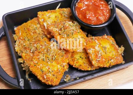 raviolis de pâtes fourrées au fromage frit et au pain croustillant et sauce à la marinara aux tomates Banque D'Images