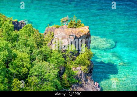 Woman est assise sur les rives du lac Huron, dans la péninsule Bruce, dans la baie Georgienne, en Ontario, au Canada. Banque D'Images