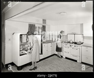 Femmes de ménage utilisant des appareils de cuisine modernes pour la publicité dans le 1940s. Image de 8 x 10 pouces négatifs. Banque D'Images