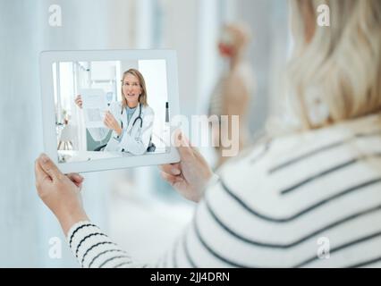 Chaque patient porte son propre médecin à l'intérieur de lui. Une femme méconnaissable utilisant une tablette numérique à la maison. Banque D'Images