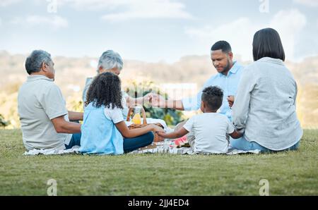 Être une famille signifie que vous faites partie de quelque chose. Famille priant dehors. Banque D'Images