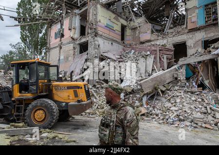 Kramatorsk, Ukraine. 21st juillet 2022. Un soldat ukrainien se tient devant les ruines de l'école détruite de Kramatorsk. Alors que la Russie intensifiée son opération militaire en Ukraine, une école de Kramatorsk a été frappée et détruite par des roquettes russes en début de matinée de jeudi, 21 juillet, les responsables ukrainiens ont affirmé avoir découvert au moins trois corps. Kramatorsk, une ville centrale ferroviaire stratégique de plus de 150 000 personnes avant l'invasion russe, deviendra plus probablement le principal centre d'intérêt des forces russes à l'est. Crédit : SOPA Images Limited/Alamy Live News Banque D'Images