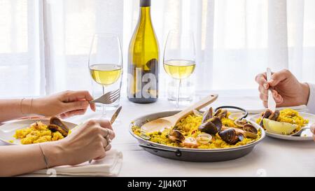 Couple mangeant des paella de fruits de mer dans le restaurant de Valence, Espagne. Image typique de style de vie de plat espagnol. Banque D'Images