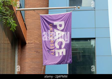 Un drapeau de l'école couleur lavande de l'Université Pace sur un bâtiment à Lower Manhattan, New York Banque D'Images