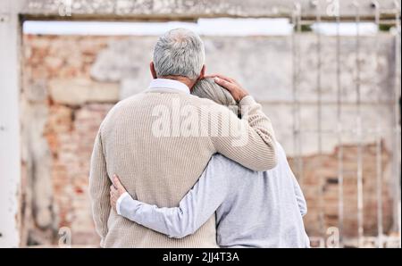 Le chagrin est lui-même un médicament. Un couple senior se réconfortant les uns les autres après avoir perdu leur maison à cause d'un incendie. Banque D'Images