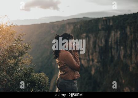 jeune femme touriste utilisant un appareil photo rétro vintage. Jeune femme à la mode qui prend des photos dans la nature au coucher du soleil Banque D'Images