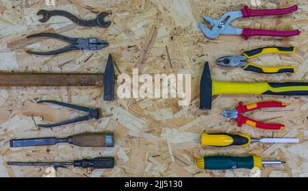 Anciens outils rouillés par rapport aux outils modernes sur la feuille OSB. Concept : mise à niveau de l'équipement. Outils : marteau et pince, burin et tournevis, poinçon. Banque D'Images