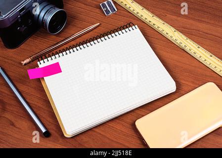 Message important présenté sur l'ordinateur portable de bureau avec appareil photo d'époque, téléphone portable, règle et aiguiseur. Informations de base sur le bloc-notes de la table avec Banque D'Images