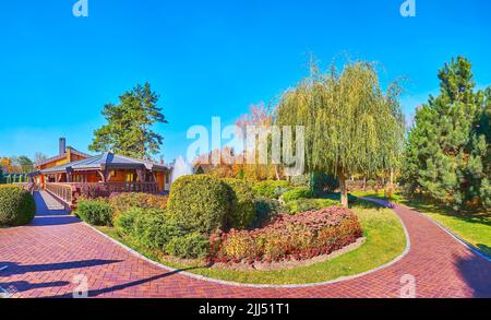 Panorama avec de magnifiques massifs de fleurs de Sedum et de marigolds, buissons de genévrier, thujas, saule et pins, Mezhyhirya, Ukraine Banque D'Images