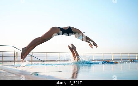 Deux jeunes athlètes plongent dans une piscine de taille olymique. Banque D'Images