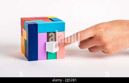 Femme organisant le cube de puzzle en mettant l'élément manquant. Dernière étape de la construction, processus de prise de décision. Enfants ou jouet de famille pour l'intelligence, la pensée logique, le développement de la créativité. Photo Banque D'Images