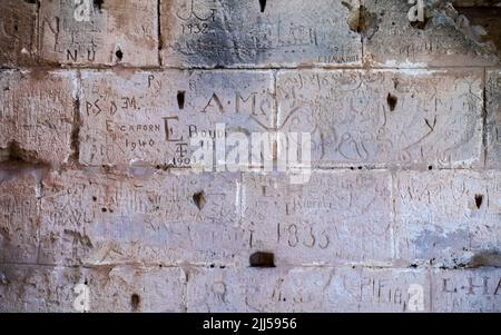 Les graffitis datant de 1835, la plupart d'entre eux de visiteurs français, sont sculptés dans un mur de l'ancien amphithéâtre romain d'El Jem (Thyssdrus) en Tunisie Banque D'Images