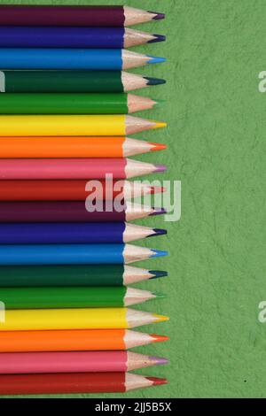 Crayons de couleur sur fond vert. Banque D'Images