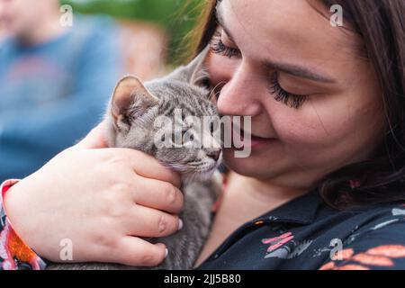 Vladivostok, Russie. 23rd juillet 2022. Une femme tient un chaton nouvellement adopté dans sa poitrine au parc Minny Gorodok lors d'un événement d'adoption de chat errant à Vladivostok, Russie, 23 juillet 2022. Credit: Guo Feizhou/Xinhua/Alamy Live News Banque D'Images