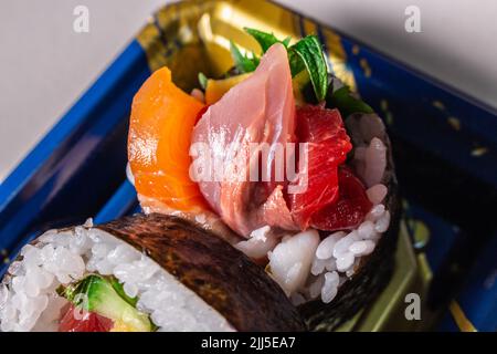 Sortez le Kaisen Maki Zushi dans un plateau alimentaire en plastique Norimaki sur l'image, déployé par la feuille de shiso, le saumon, l'œuf frit (Tamago Yaki), le thon (Maguro) et le concombre Banque D'Images