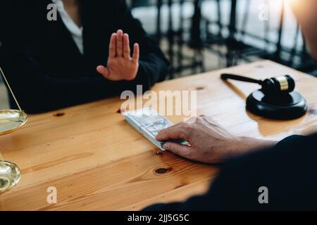 Vue rapprochée d'un avocat refusant la corruption d'un client, faire un accord corruption, juge gavel, échelle de laiton, cabinet d'avocats, malhonnête, loi Banque D'Images