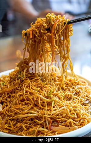 Une assiette de délicieuses nouilles frites de style Hong Kong avec sauce soja Banque D'Images