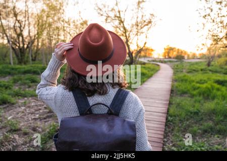 Femme portant un chapeau marchant dans le parc Banque D'Images