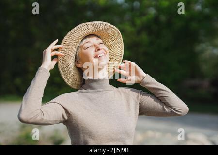 Bonne femme mûre avec les yeux fermés appréciant le soleil Banque D'Images