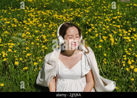 Femme enceinte assise au milieu des plantes le jour ensoleillé Banque D'Images