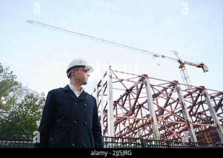 Ingénieur portant un casque résistant debout sur le chantier de construction Banque D'Images