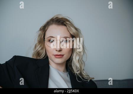 Femme d'affaires confiante aux cheveux blonds portant des lunettes Banque D'Images
