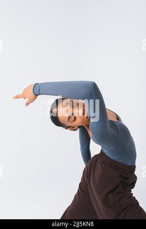 Jeune danseur de ballet passionné dansant sur fond blanc Banque D'Images