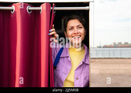 Bonne femme debout près d'un rideau dans la cabine photo Banque D'Images