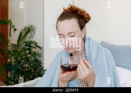Femme sentant du thé dans une tasse à la maison Banque D'Images