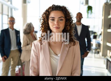 Jeune femme d'affaires debout avec des collègues au bureau Banque D'Images