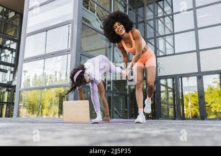 Une femme riant par une femme âgée pratiquant le yoga sur la piste de marche Banque D'Images